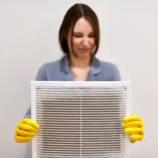 Woman changes her dirty air filter.